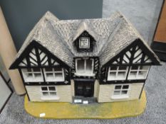 A vintage hand made wooden Dolls house in the style of a traditional cottage