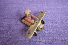 A Schuco tin plate and clockwork Aeroplane in yellow with black stars on wing with felt covered