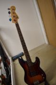 A Squier by Fender 'P' bass, with after market and original scratch plates, and padded gig bag