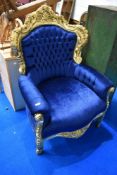 A French style armchair with gilt foliate frame and blue button back upholstery