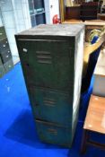 A vintage industrial locker having three compartments