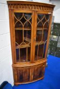 A reproduction yew wood corner display cabinet having cupboard under