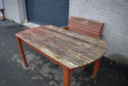 A large stained wood garden table and bench