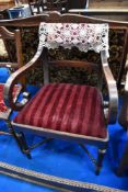 A Georgian mahogany armchair having scroll arms and turned cross stretcher