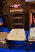 A traditional ladder back chair with strung seat
