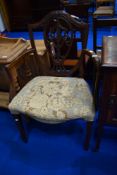 An early 20th Century mahogany armchair having overstuffed seat and shield back
