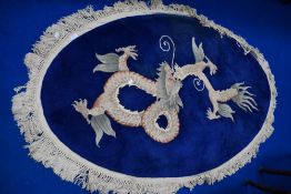 A Chinese oval fireside or similar rug, having blue ground with dragon design