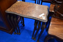 A nest of three burr walnut tables having carved edge with cabriole legs and ball and claw feet