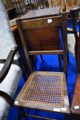 A Victorian oak bedroom chair having cane seat