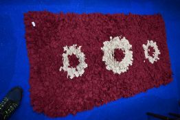 A pegged rag rug, in burgundy and cream tones, approx. 150 x 75cm