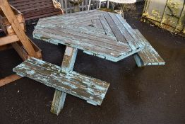 A triform garden table, labelled Tabula, with integral seating