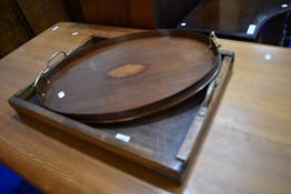 An Edwardian mahogany tray of oval form with inlaid shell decoration and an industrial style oak