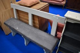 A painted wood bench having rail back and later upholstered seat, width approx. 142cm