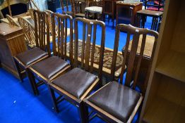 A set of four early 20th Century oak rail back dining chairs having vinyl seats