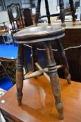 A traditional four legged stool on turned frame