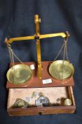 An early 20th century chemist or apothecary class B scale set mounted on mahogany draw with weight