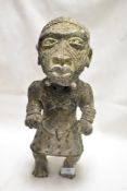 An antique African Benin Bronze ritual statue of a female villager in traditional tribal dress
