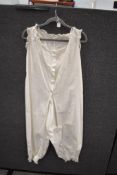 A scarce all in one Victorian cotton undergarment with lace to cuffs, arm openings and neckline.