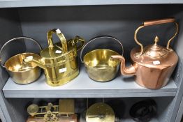 A copper stove kettle with a brass watering can and two brass jam pans.