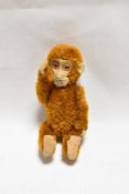An early 20th century German Schuco monkey perfume or scent bottle having piccolo brown mohair