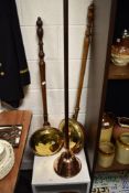 An early 20th century copper posser with two brass and copper bed warming pans.