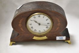 An Edwardian balloon style mantel clock having inlaid mahogany case on brass feet.