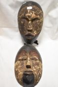 Two early 20th century African tribal ritual masks from the Lega Bwami people, One having eyes