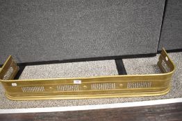 An early 20th century brass fire fender with pierced design. 3ft long.