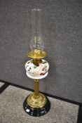 A Victorian oil lamp having brass column with hand painted milk glass well.