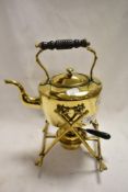 A Victorian spirit burning kettle with stand in brass with ebonised handle.