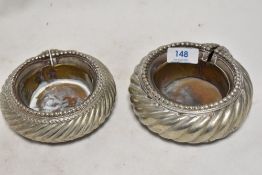 A pair of antique Manilla slave bracelets in a silver tone metal, with later brass liners added to