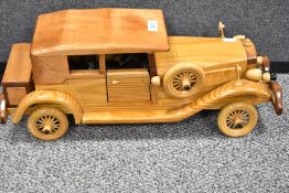 A vintage wooden pine model of a large American saloon car.