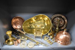 A selection of copper and brass wares including fire side items, large weighing pan, graduated pig