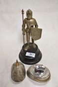 Two military related table top cigarette lighters one in the form of a helmet and a similar
