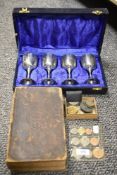 A selection of collectable coins and currency with a set of goblets and a Victorian bible.