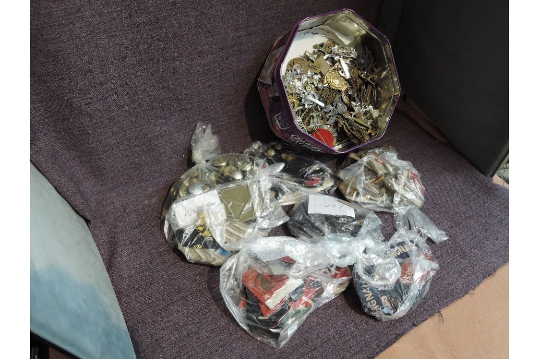 A tin containing mainly British Military Cap Badges, Buttons, Cloth Badges including RAF, Army, Navy