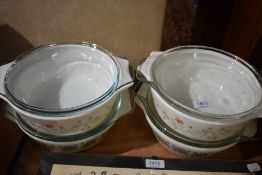 Four Pyrex oven to tableware casserole dishes with lids.