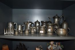 A large collection of early 20th century pewter wares including graduated tankards, toast rack and