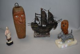 A Norwegian style wooden carved candle holder with a Scotty dog study and a model galleon.