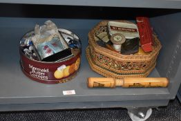 A selection of sewing and haberdashery items including buttons, bobbins and a needle tin.