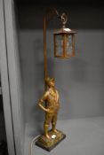 An early 20th century French figural lamp base of a boy under a street lantern.