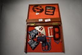 A wooden box containing an assortment of Art Deco buckles.