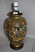 A vintage Taisho Japanese Satsuma ware lamp base on wooden stand.