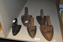Five antique stove top irons all cast iron.