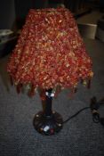 A vintage kitsch lamp with metal base and plastic crystal shade.