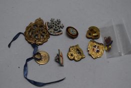 A selection of military themed badges including an RAF cap badge.