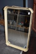 An Art Deco hall way mirror with bevel edged glass and formed painted frame.