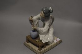 A Lladro figurine study a Japanese Geisha girl arranging flowers, AF.