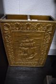 An embossed brass umbrella and stick stand with a galleon design and drip tray.