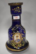 A blue glass receptacle of bell shaped form, having hand painted and transfer decoration.